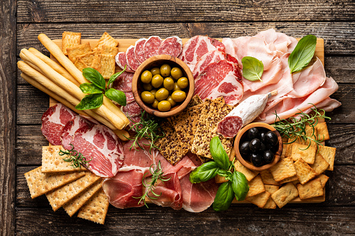 Appetizers with differents antipasti, charcuterie, snacks and red wine. Sausage, ham, tapas, olives and crackers for buffet party. Top view, flat lay